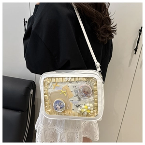 Macro detail of white ita bag with transparent window and decorative anime charms