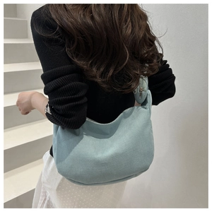 Close-up of light blue corduroy hobo bag texture with a matching small coin purse