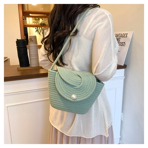 Detail of light green cotton rope woven crossbody bag with a large pearl buckle closure