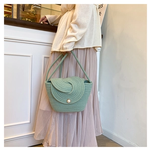 Detail of light green hand-woven summer beach bag with elegant pearl button closure