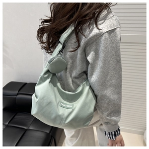 Detail of mint green crescent hobo bag made of durable nylon with a small round coin purse