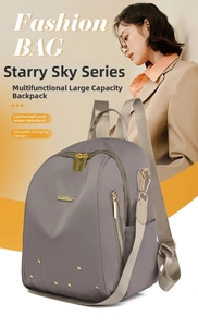 Détails du sac à dos gris imperméable montrant les rivets étoiles dorés et les zips multiples