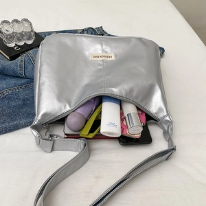 Sac hobo argenté métallisé à grande capacité montrant les essentiels quotidiens