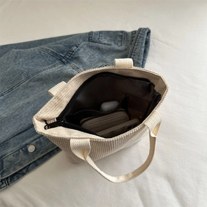 Corduroy handbag with internal pockets and zipper shown from a top-down angle