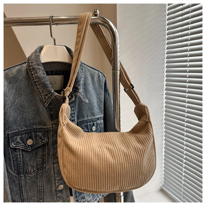 Detail showing the khaki corduroy texture and crescent shape of the casual shoulder bag