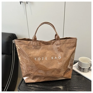 Detail of a brown tote bag featuring a double-layer PVC waterproof cover and white text