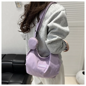 Dettaglio della borsa tote in velluto a coste viola con mini portamonete e etichetta logo