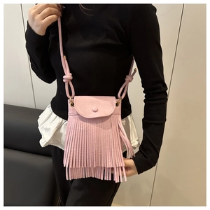Close-up of pink crossbody bag with long fringes and decorative knotted strap detail