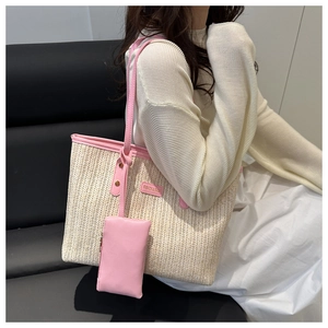 Dettaglio della borsa tote in paglia con finiture rosa e pochette coordinata