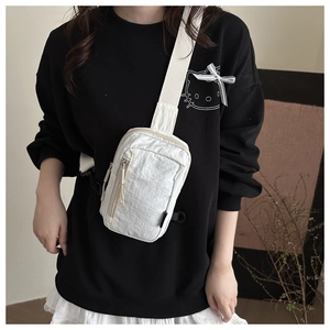 Detail showing the white crinkled nylon texture and double zippers of the crossbody chest bag