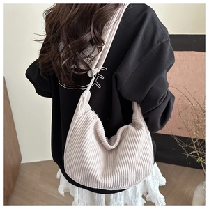 Detail of cream corduroy hobo bag showing thick texture and knotted wide shoulder strap
