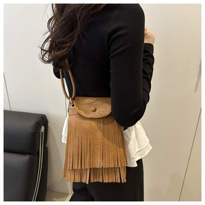 Close-up of brown fringe crossbody bag showing tassel detail and premium faux leather finish