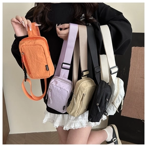 Close-up of five colorful mini nylon crossbody bags showing adjustable shoulder straps