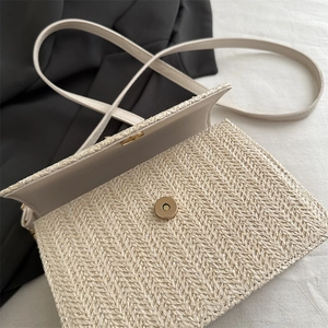 Minimalist straw woven crossbody bag with metal magnetic clasp and textured finish