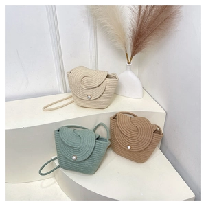 Detailed spiral woven pattern on straw bucket bags with pearl buckle in three colors