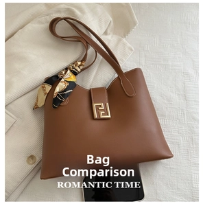 Detail view of large brown leather tote with gold buckle and scarf showing phone size scale
