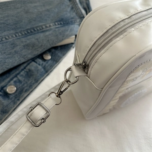 White PU leather crossbody bag with silver zippers and adjustable shoulder strap