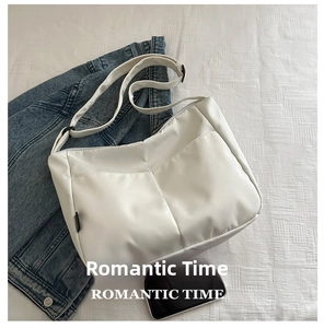 Phone size reference of a large white canvas tote bag with front pockets and adjustable strap