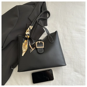 Chic black leather tote bag with large gold buckle and decorative floral silk scarf detail