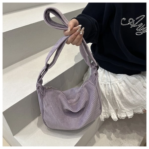 Detailed close-up of purple corduroy texture and adjustable strap on half-moon bag