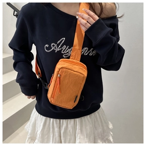 Detalle del bolso bandolera de nailon naranja con tela impermeable y correa ajustable