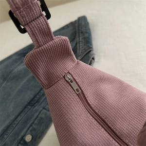 Pink corduroy crossbody bag with silver zipper and adjustable strap, casual dumpling style