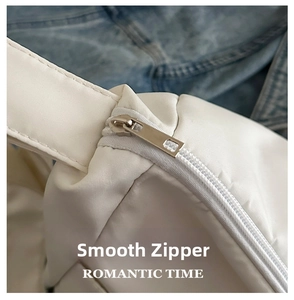 Detail of silver zipper and white nylon fabric texture on a modern shoulder bag