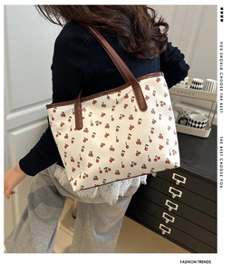 Vue détaillée du grand sac cabas avec motif cerise et anses marron porté par un mannequin