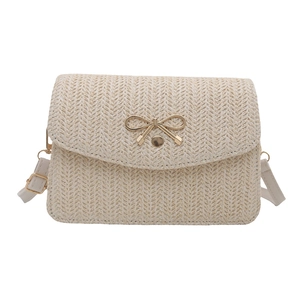 Minimalist woven crossbody bag for women with a golden bow metal accessory on cream flap
