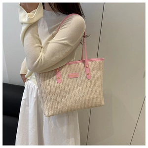Gros plan du sac cabas en paille avec garniture en cuir rose et rivets sur un mannequin