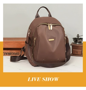 Détail d'un sac à dos oxford marron foncé avec zips dorés et moulin à café vintage