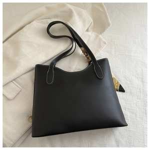Détail d'un sac cabas noir mat avec coutures blanches contrastées et foulard décoratif