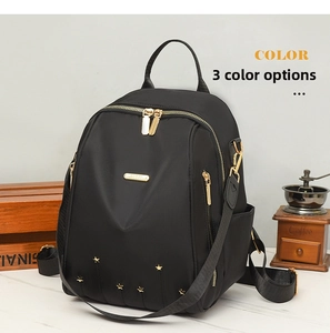 Détail d'un sac à dos en nylon noir avec rivets étoiles dorés et fermetures éclair
