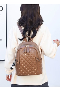 Brown quilted PU leather backpack with gold rivets and cute panda keychain on a model