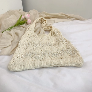 Cream knit tote bag featuring wavy pearl accents for summer beach vacation style