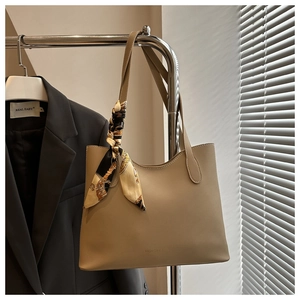 Detail of khaki tote bag with fashion text and vintage floral silk scarf on handle