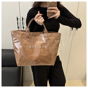 Close-up of waterproof PVC layer over brown Tyvek tote bag with white TOTE BAG text
