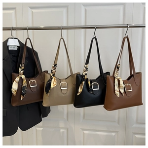 Four stylish large leather tote bags in various colors displayed with decorative scarves