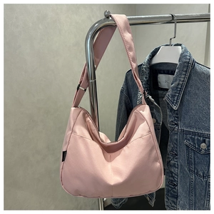 Detailed view of pink casual nylon hobo shoulder bag hanging on a minimalist steel hanger