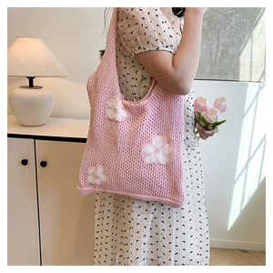 Detailed knit texture of pink crochet tote bag featuring white floral patterns