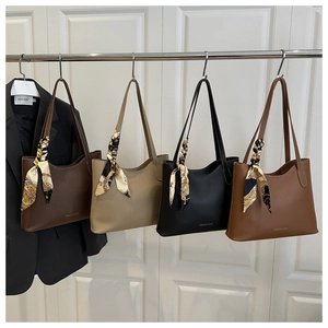 Quatre sacs cabas en marron, beige et noir avec des poignées ornées de foulards en soie