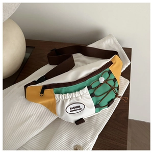 Détail macro du sac nylon tricolore avec cordon élastique et écusson mode sur le devant