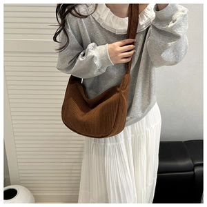 Brown corduroy crossbody dumpling bag shown on model for casual everyday styling
