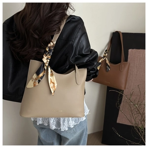 Detail view of large tote bags with colorful silk scarf accent and leather texture