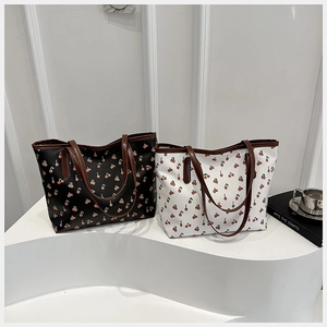 Deux grands sacs cabas noir et blanc avec motifs de cerises rouges et anses marron