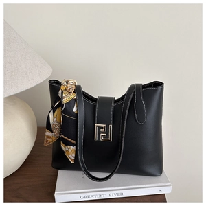 Detail of black tote bag with white stitching, gold buckle and decorative silk scarf