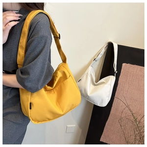Detail of canvas tote bags in yellow and white featuring adjustable shoulder straps