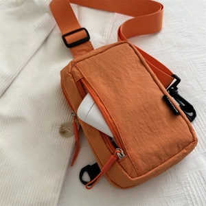 Bolso bandolera minimalista de nailon naranja con bolsillo frontal y correa ajustable