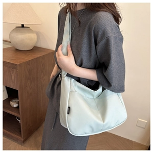Detail of mint green tote bag featuring a brand tag and durable nylon fabric