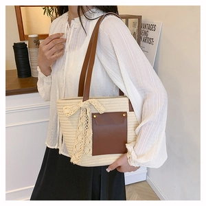 Detail of handwoven cream tote bag featuring a leather pocket and elegant lace bow detail